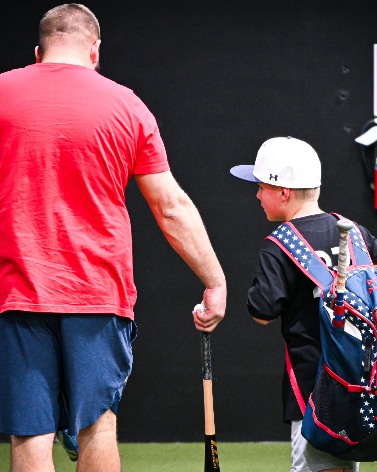 baseball coach walking with baseball player